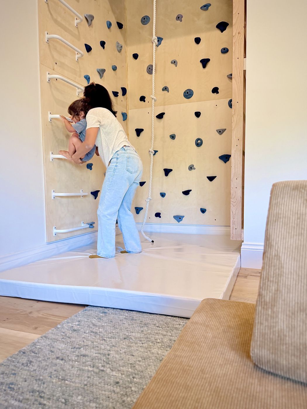Adult helping toddler wall bars