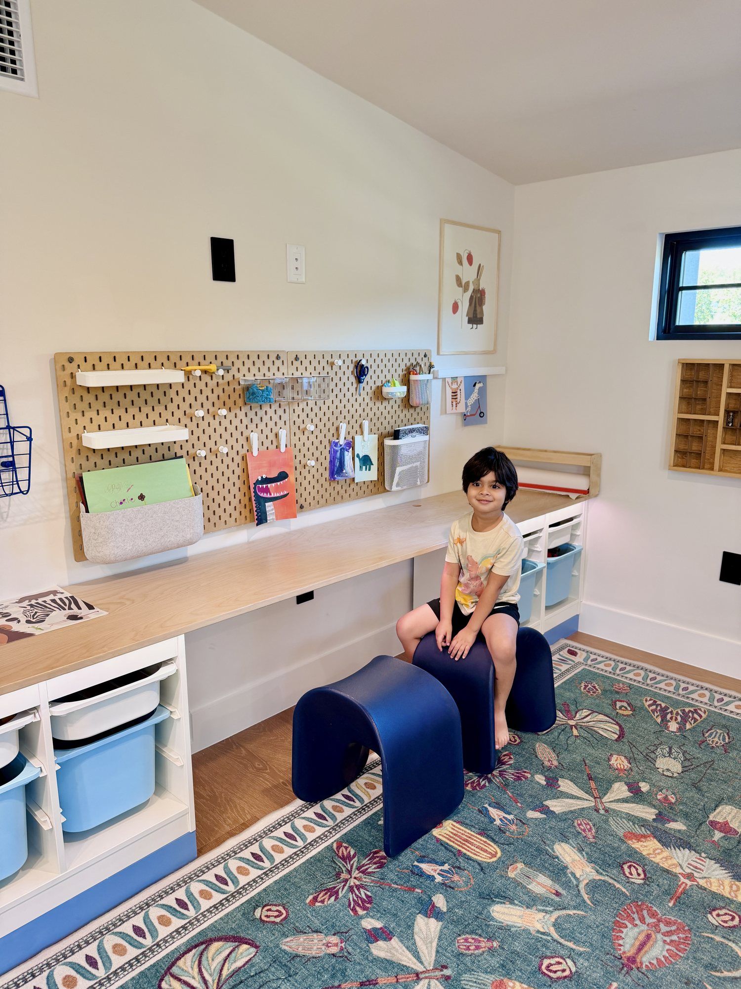 A child at the art desk with pegboard storage