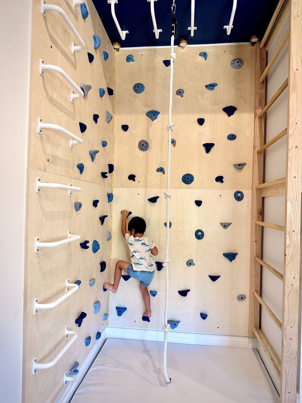Child climbing blue holds
