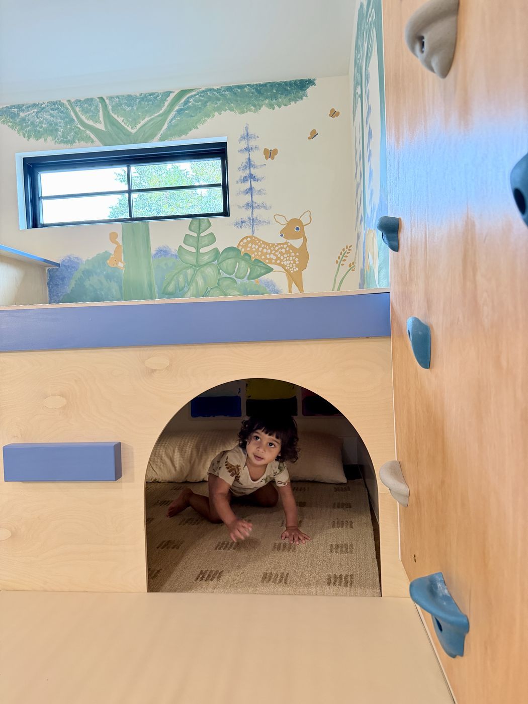 Child crawling through playhouse arch