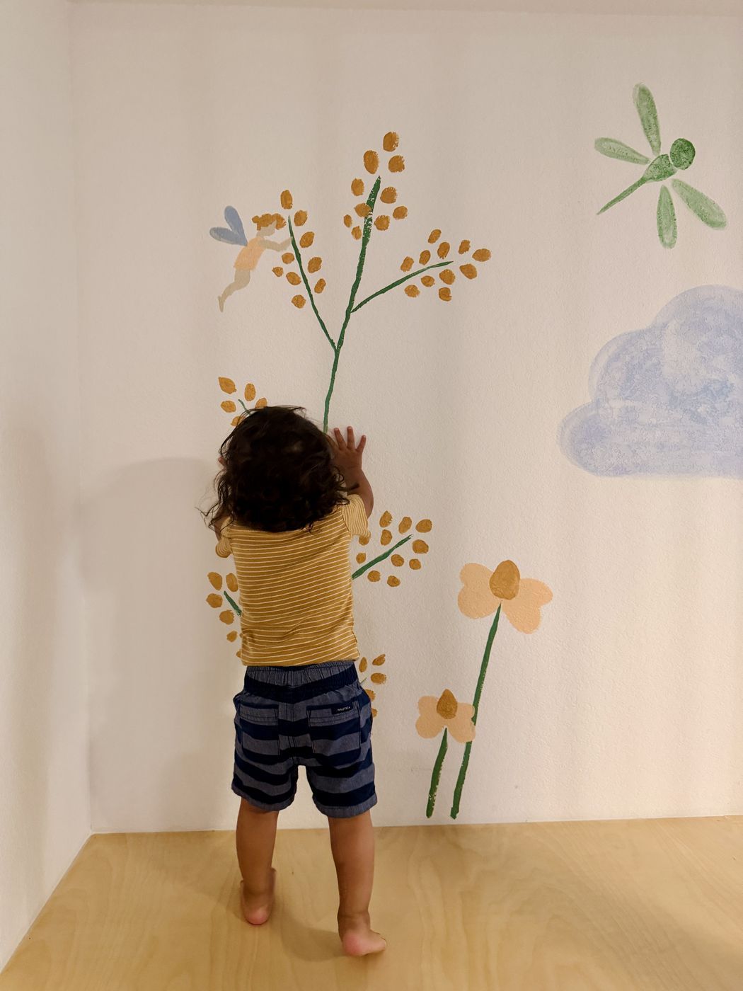 Child exploring fairy flower mural