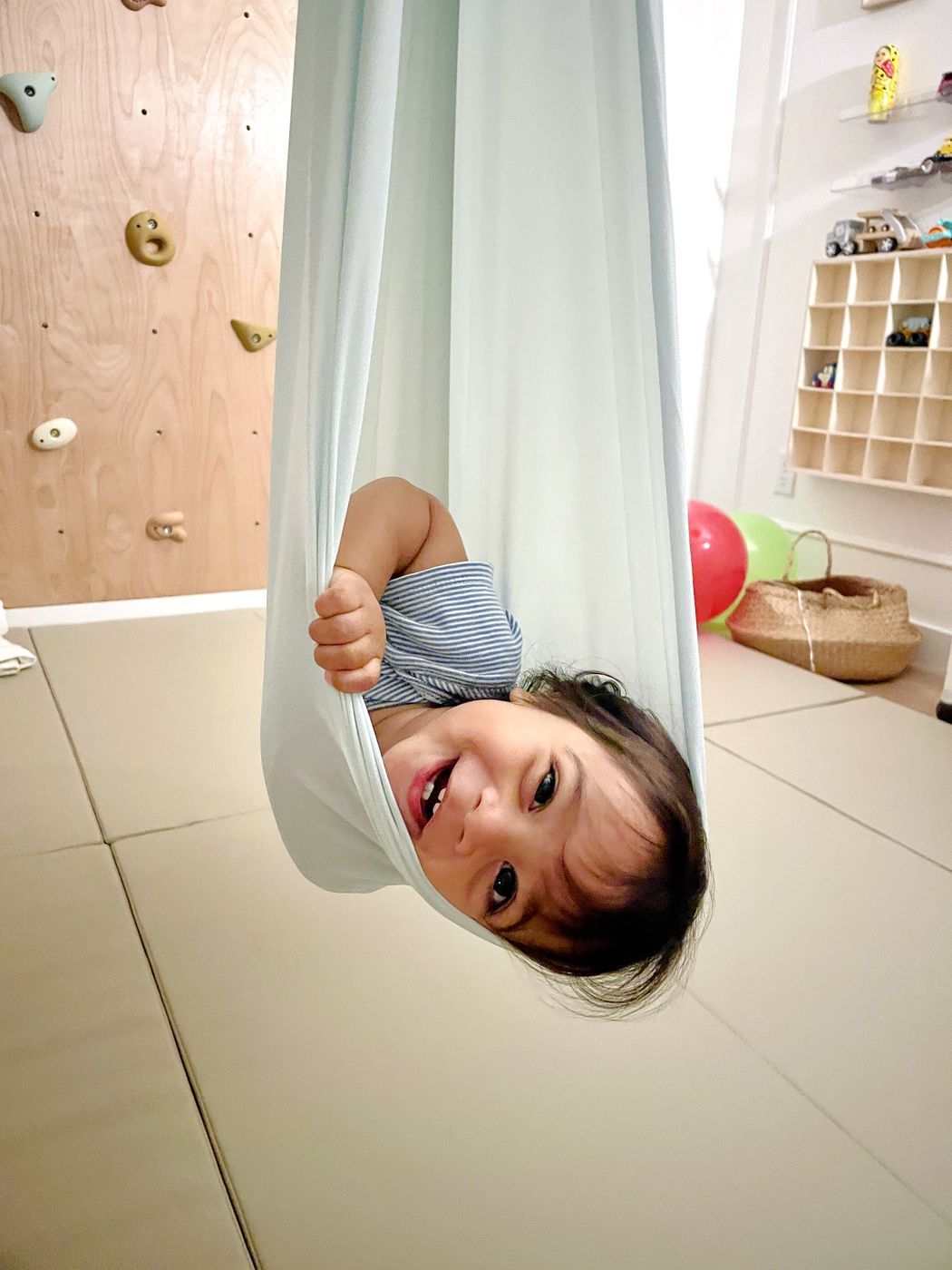 Child in pale blue fabric swing