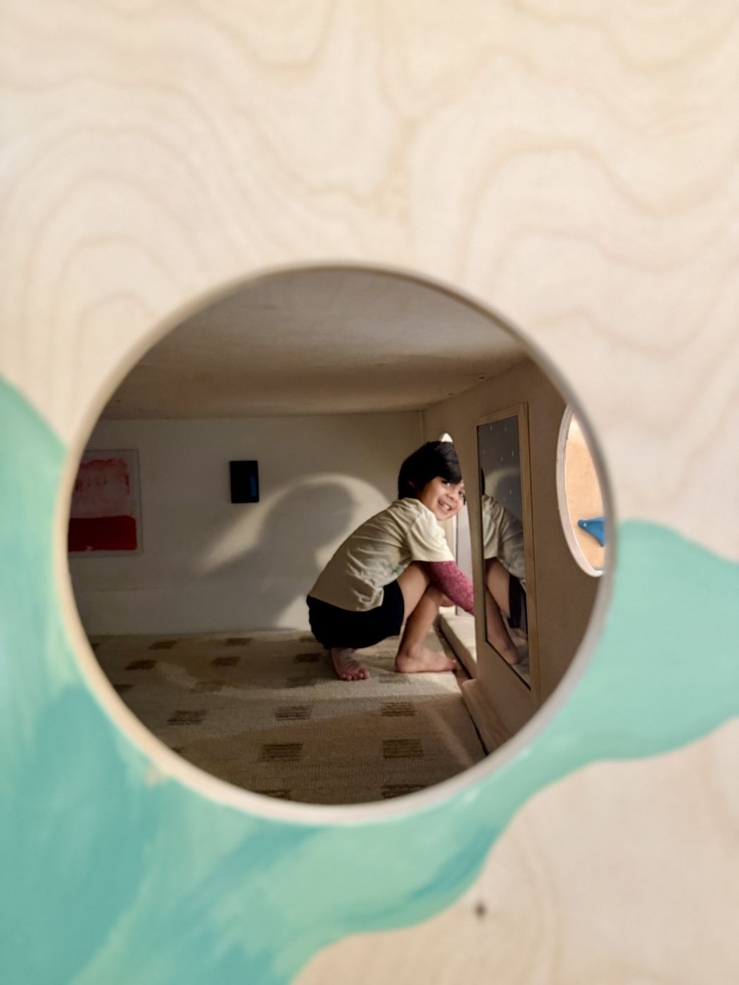 Child inside hideaway through round window