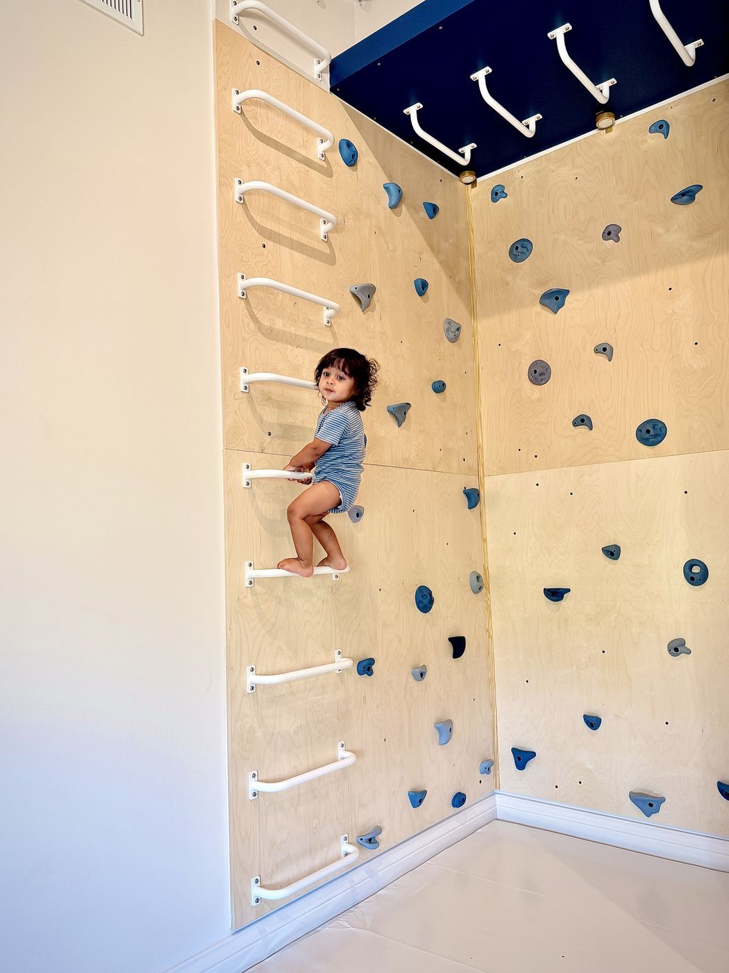 Child on corner wall bars