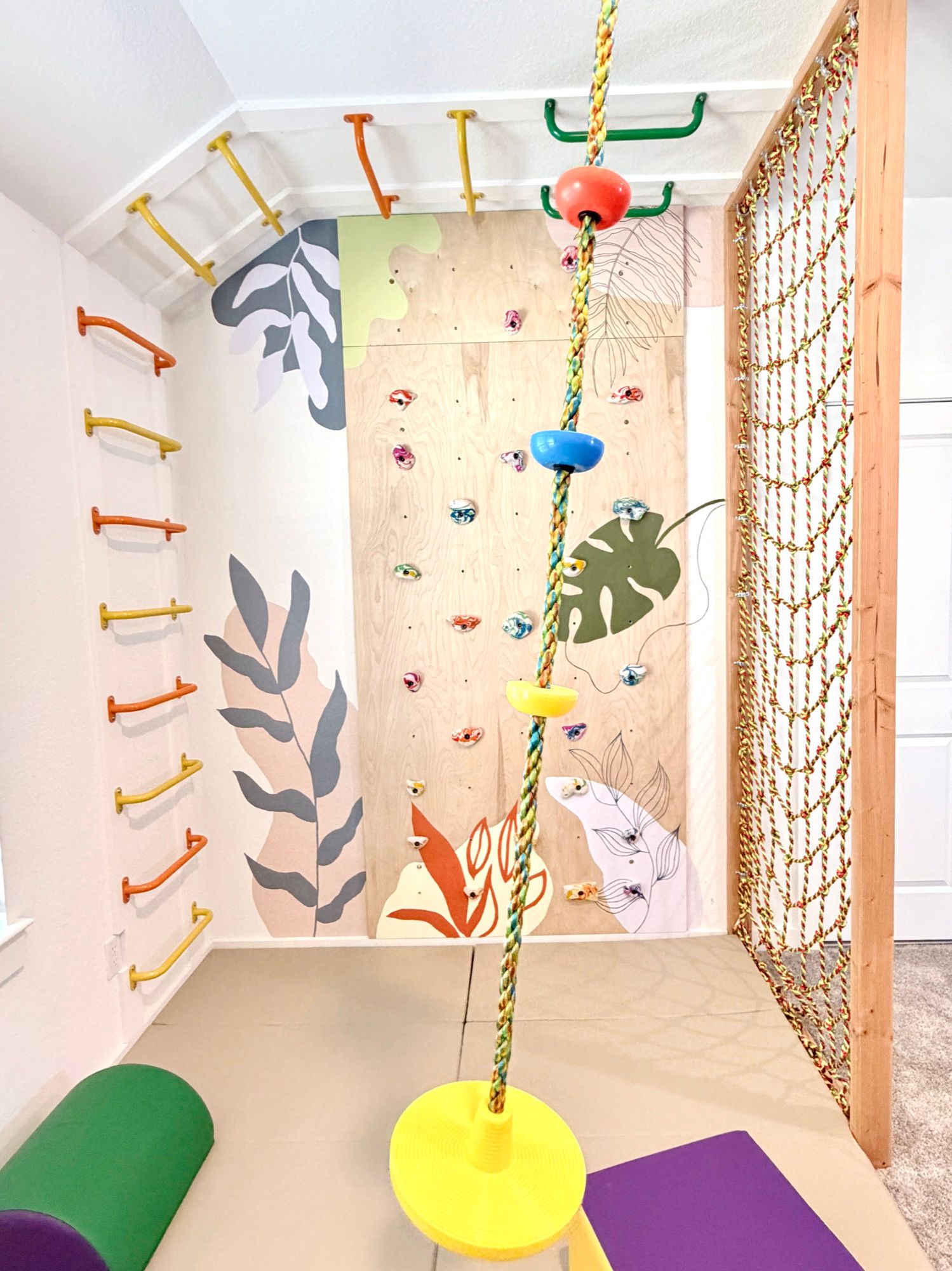 The movement nook: a climbing wall, colourful monkey bars, a disc-swing rope and a rope net