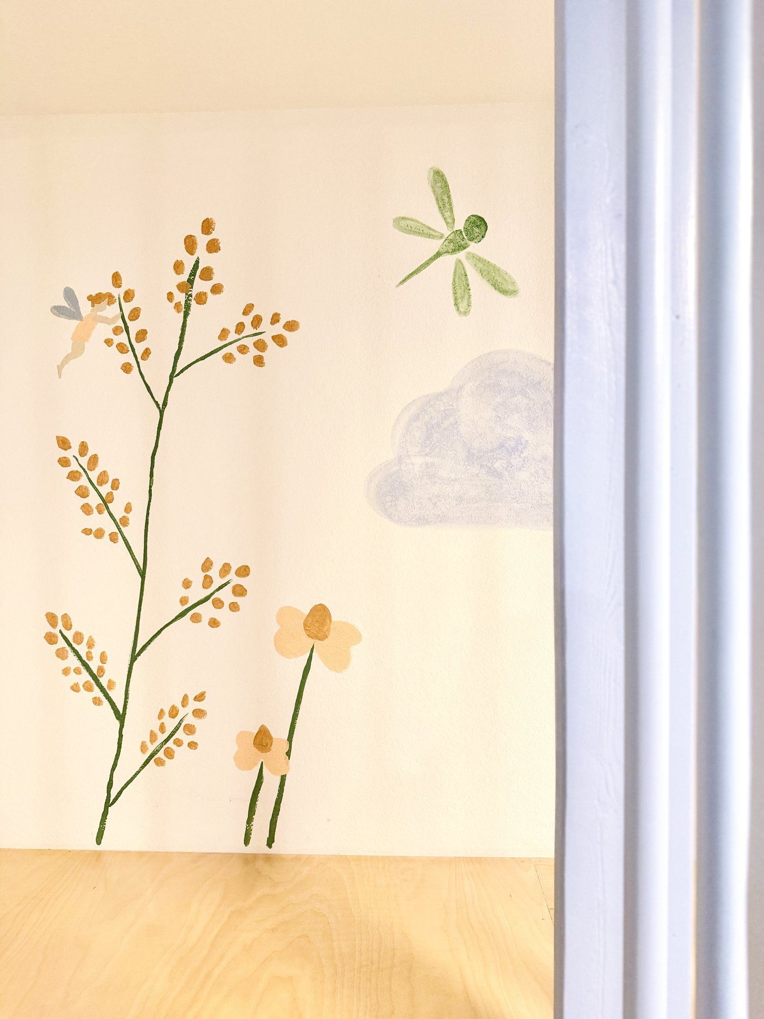 The hand-painted dragonfly and fairy on the meadow mural