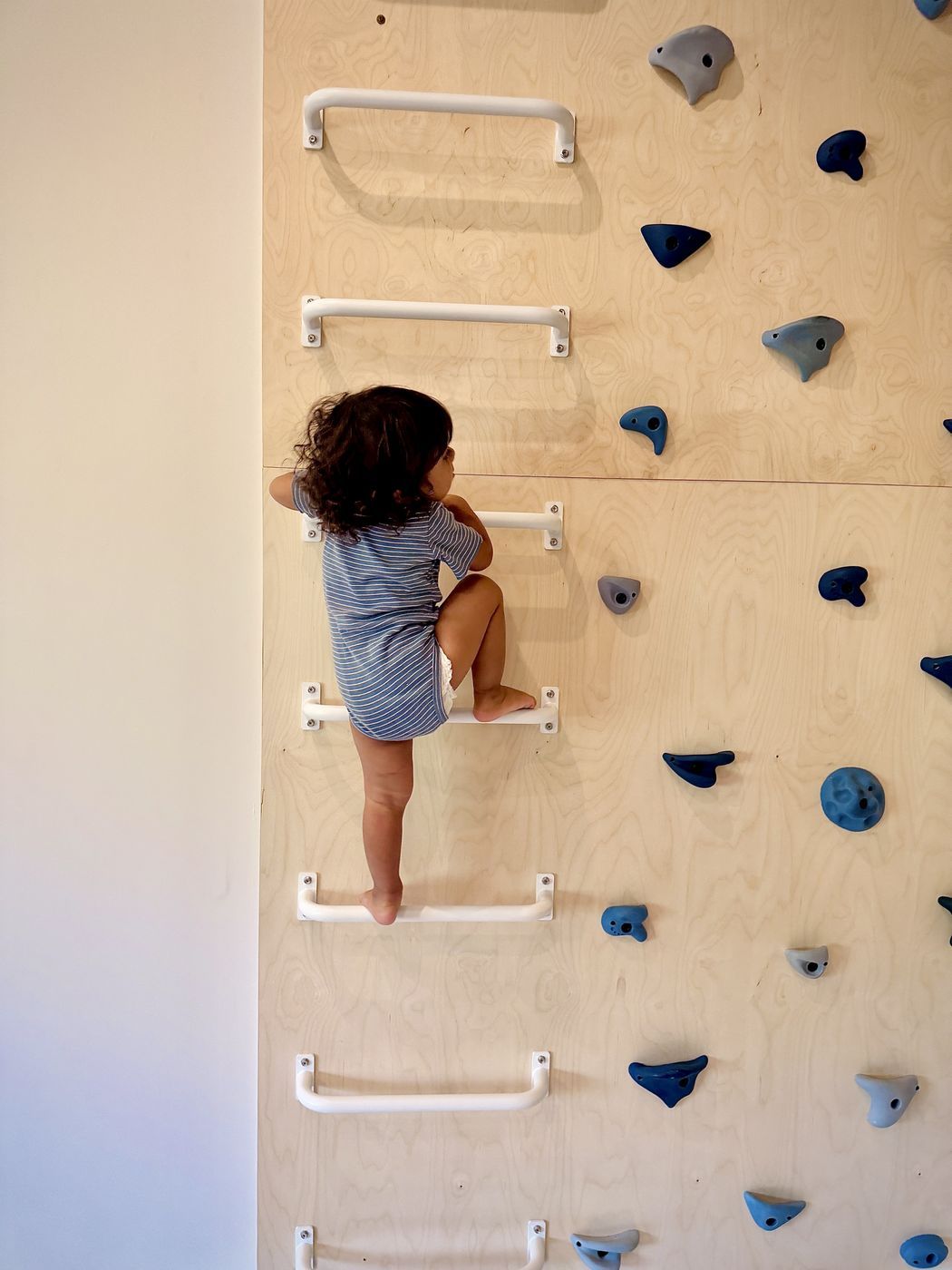 Toddler on white climbing rungs