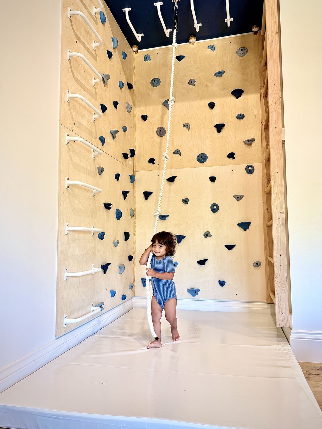 Toddler standing with climbing rope
